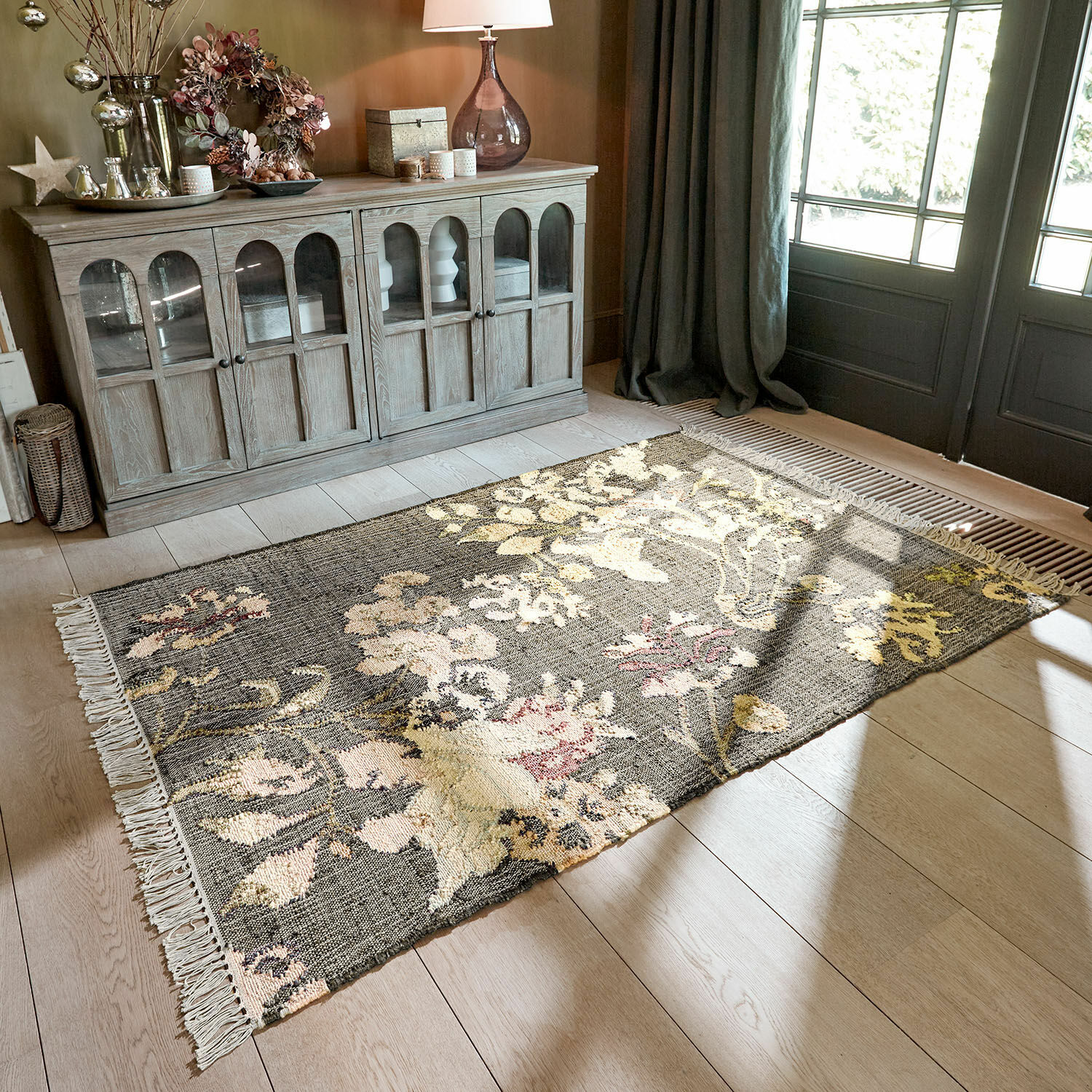 Teppich Yasirah Blumenmuster-Teppich in Grau- und Cremetönen auf hellem Holzboden im Wohnzimmer