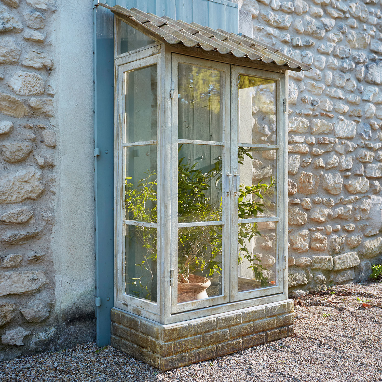 Garten-Vitrine aus weißem Holz mit Ziegelsteinbasis und Glasfenstern im rustikalen Stil