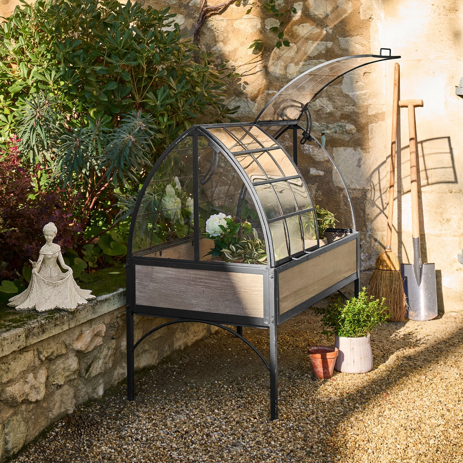 Erhöhtes Gewächshaus mit Metallrahmen und Holzpaneelen, ideal zum Pflanzenanbau im Garten.