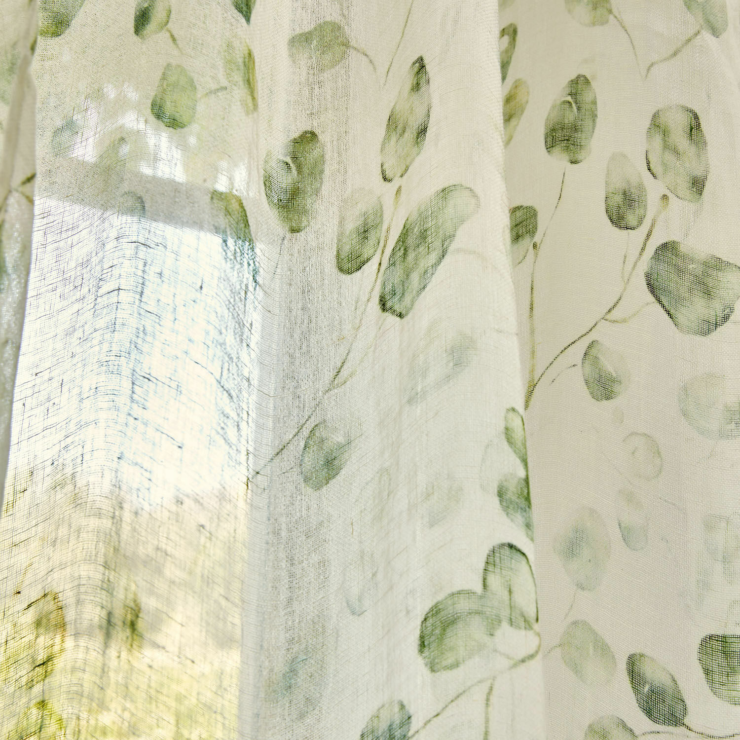 Transparenter Vorhang mit grünem Blattmuster auf hellem Stoff, dekorativer Fensterschmuck