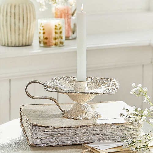 Vintage Metall-Kerzenhalter in Creme auf weißem Buch, Tischdekoration mit weißen Blumen