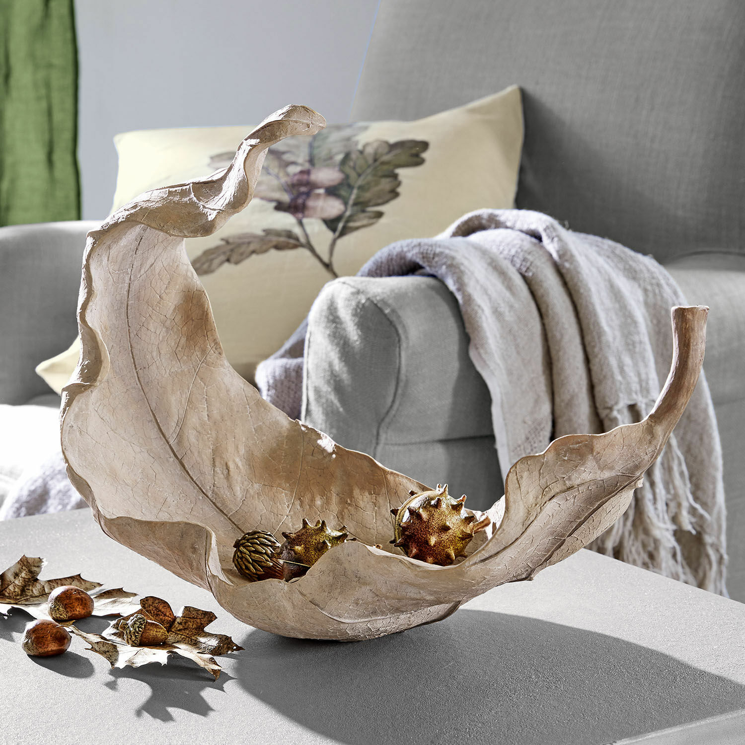 Schale Vibius Dekorative Schale in Blattform aus natürlichem Material in Beige auf einem Wohnzimmertisch