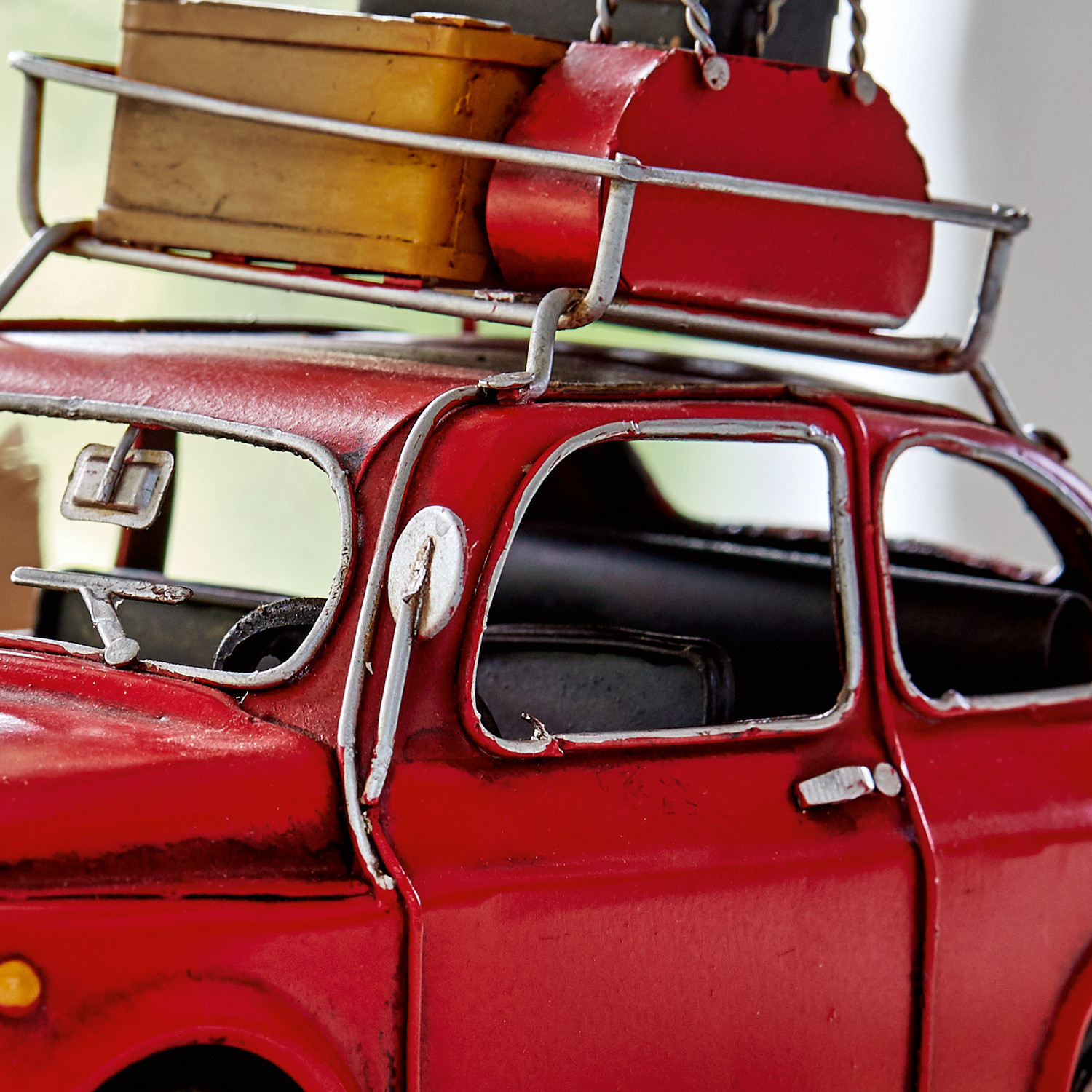 Rotes Metallmodellauto mit Dachgepäckträger und gelbem Koffer, Vintage-Dekoration für Zuhause
