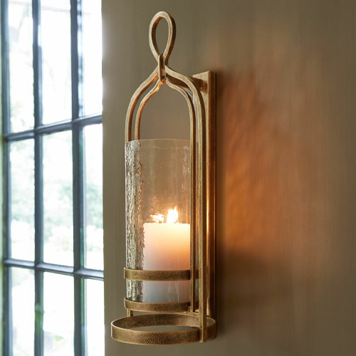 Goldfarbener Metall-Wandkerzenhalter mit klarem Glas und weißer Kerze, Wohnaccessoire