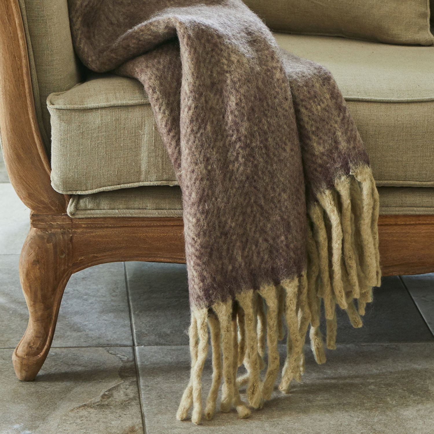 Weiche braun-beige Decke mit Fransen auf beigem Sofa, Wohntextilien und Dekoration