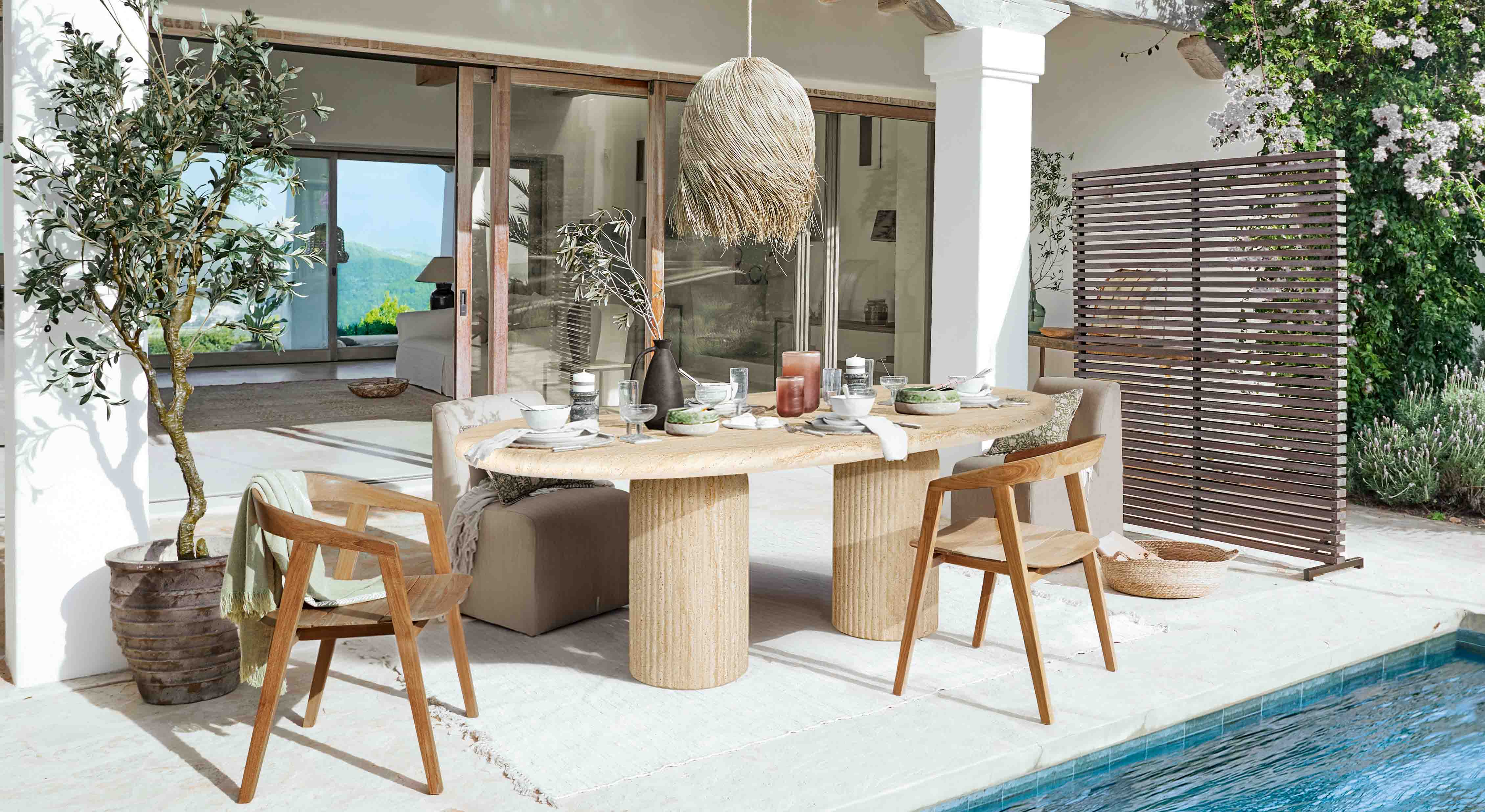 Outdoor-Essbereich mit Steintisch und Holzstühlen am Pool in natürlichem Stil