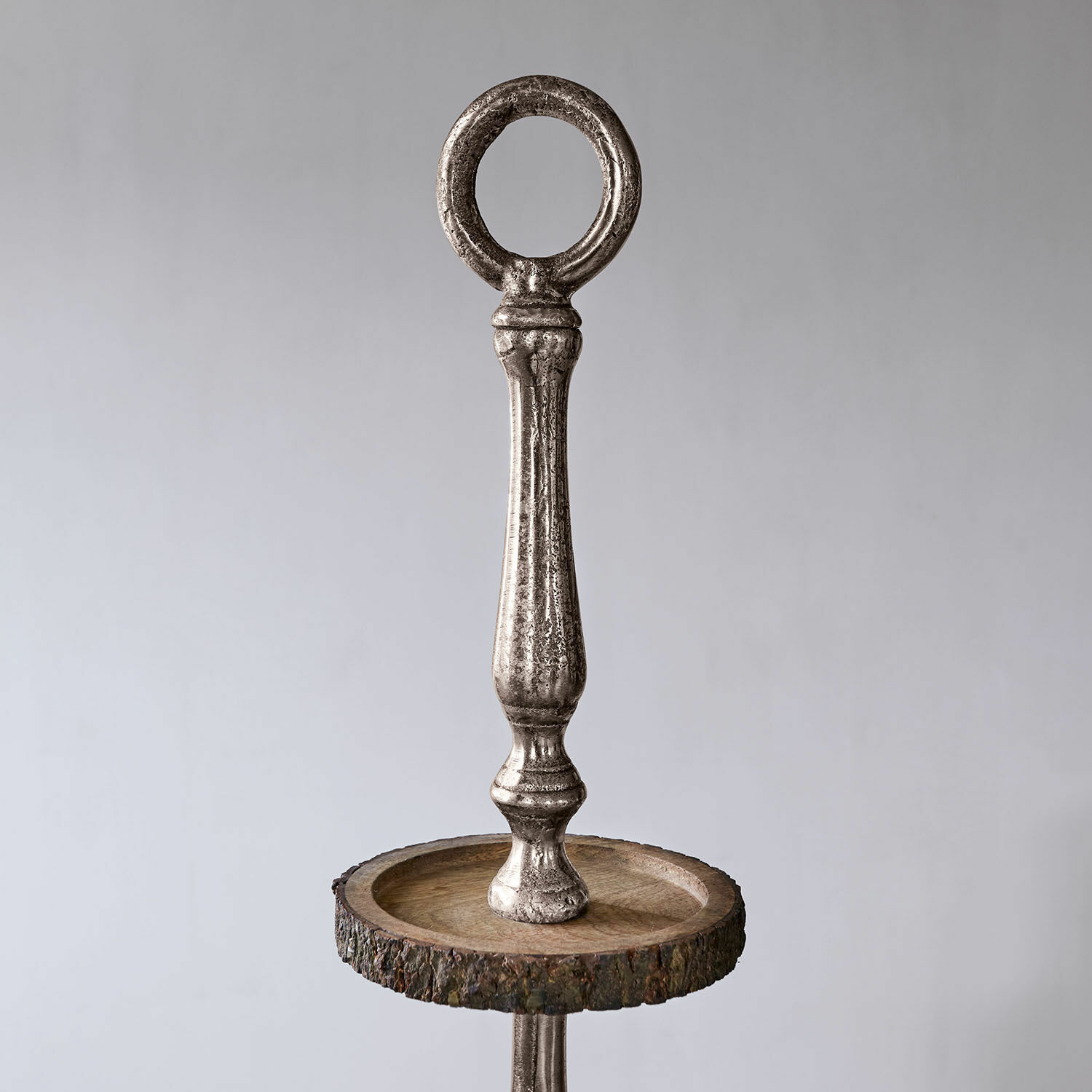 Metallgriff mit rundem Ring auf Holzplatte mit natürlicher Rinde