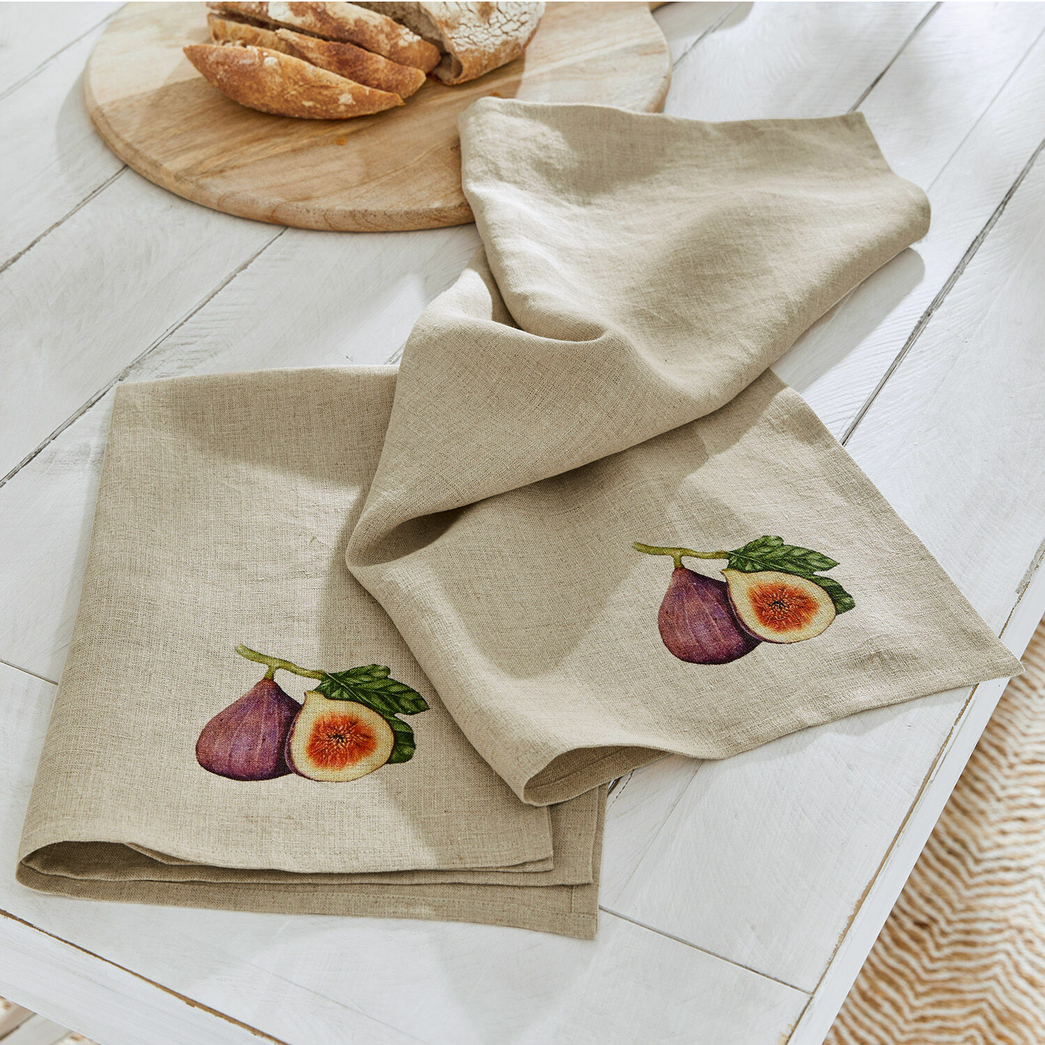 Beige Leinen-Geschirrtücher mit Feigenmotiv auf weißem Tisch, Küchenaccessoires