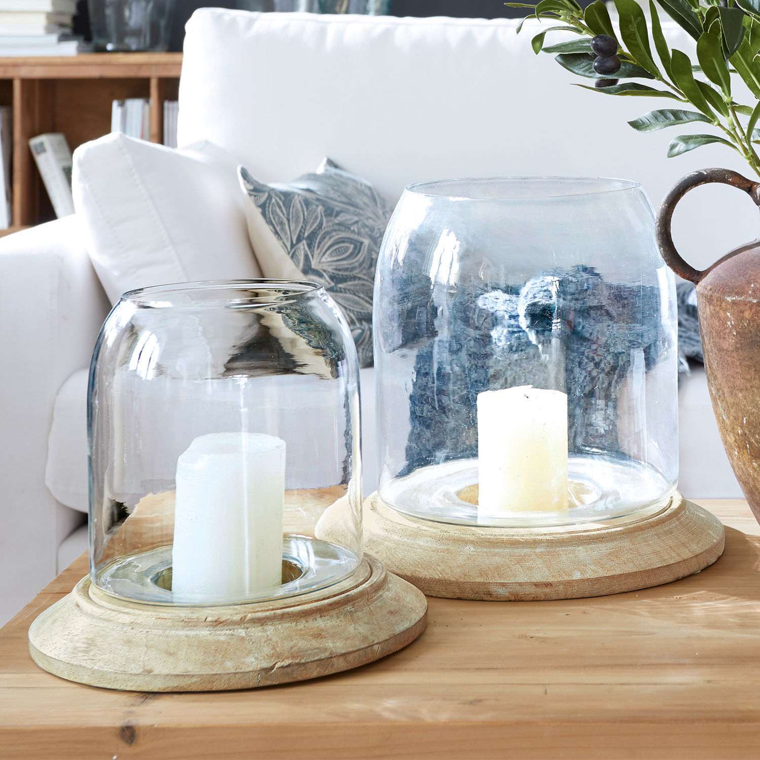Windlicht 2er Set Bran Zwei Windlichter aus Glas und hellem Holz auf Holztisch im gemütlichen Wohnzimmer