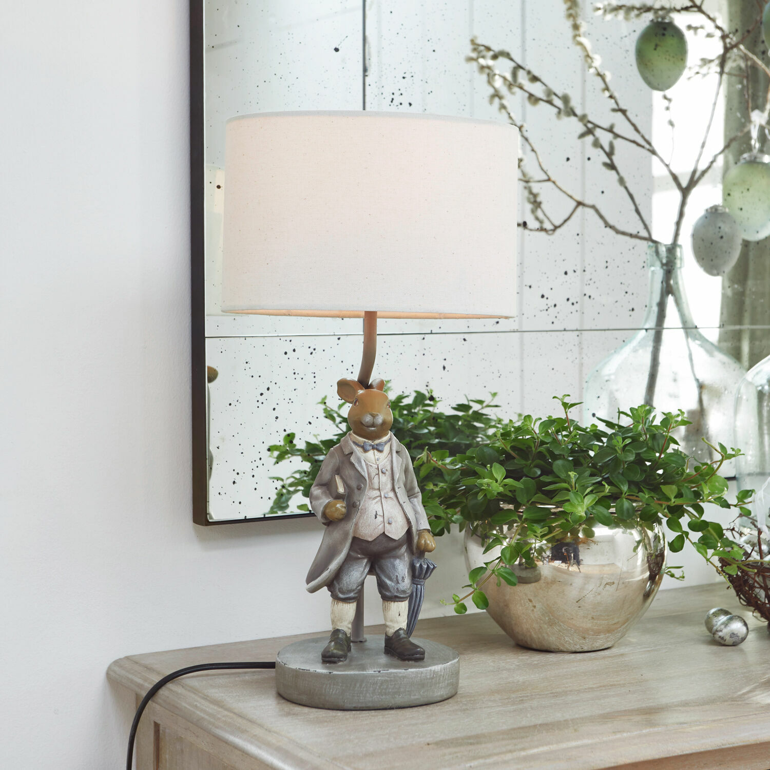 Tischlampe Cerni Tischlampe mit Hasenfigur in grauer Kleidung und weißem Lampenschirm auf Holzkommode