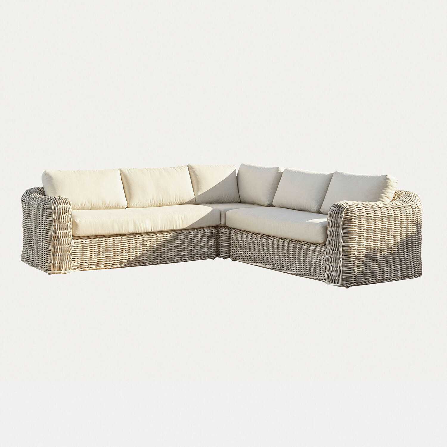 Ecksofa aus hellem Rattan mit cremefarbenen Kissen, gemütliches Wohnzimmermöbel