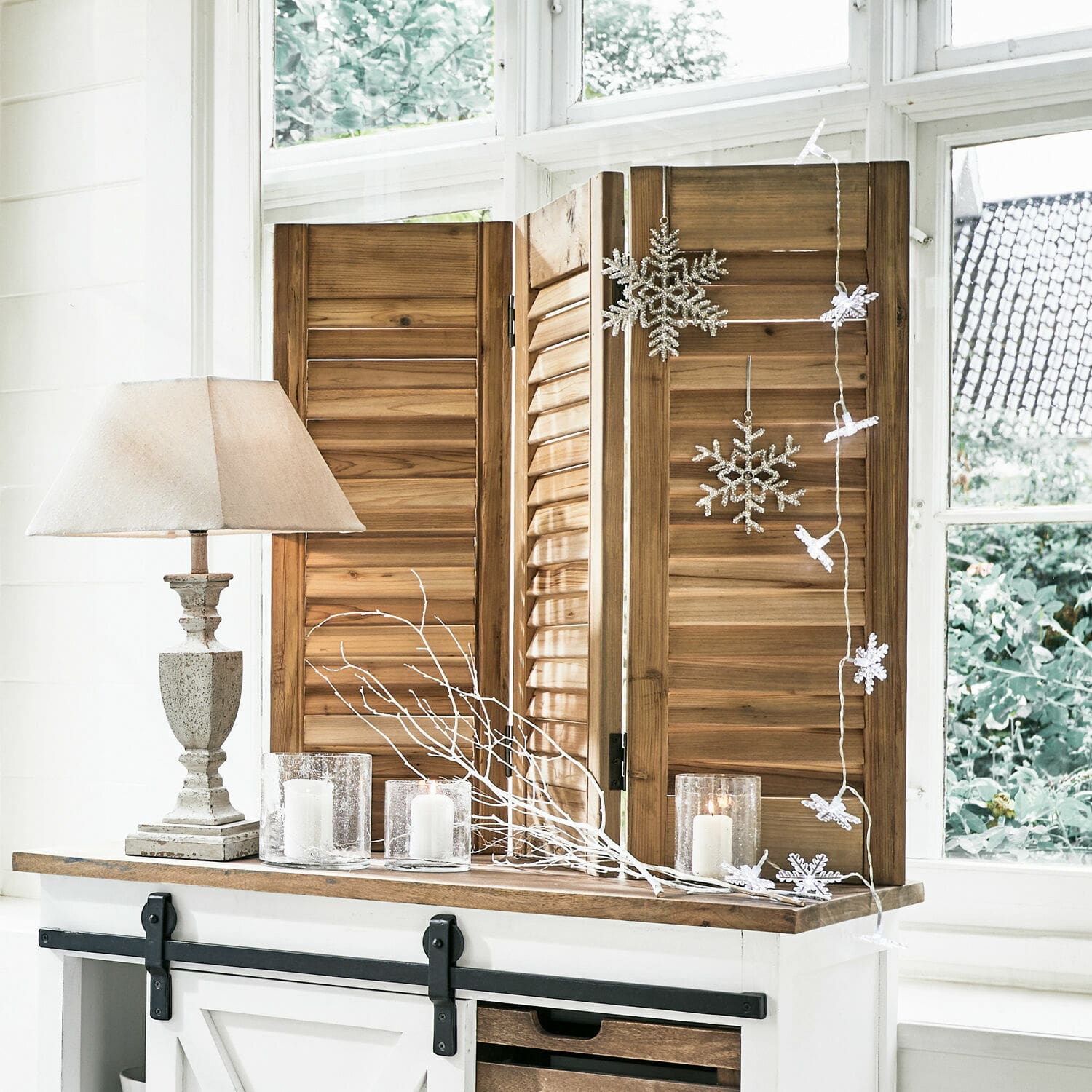 Dreiteiliger Paravent aus Naturholz mit Lampe und Kerzen auf weißer Kommode im rustikalen Stil
