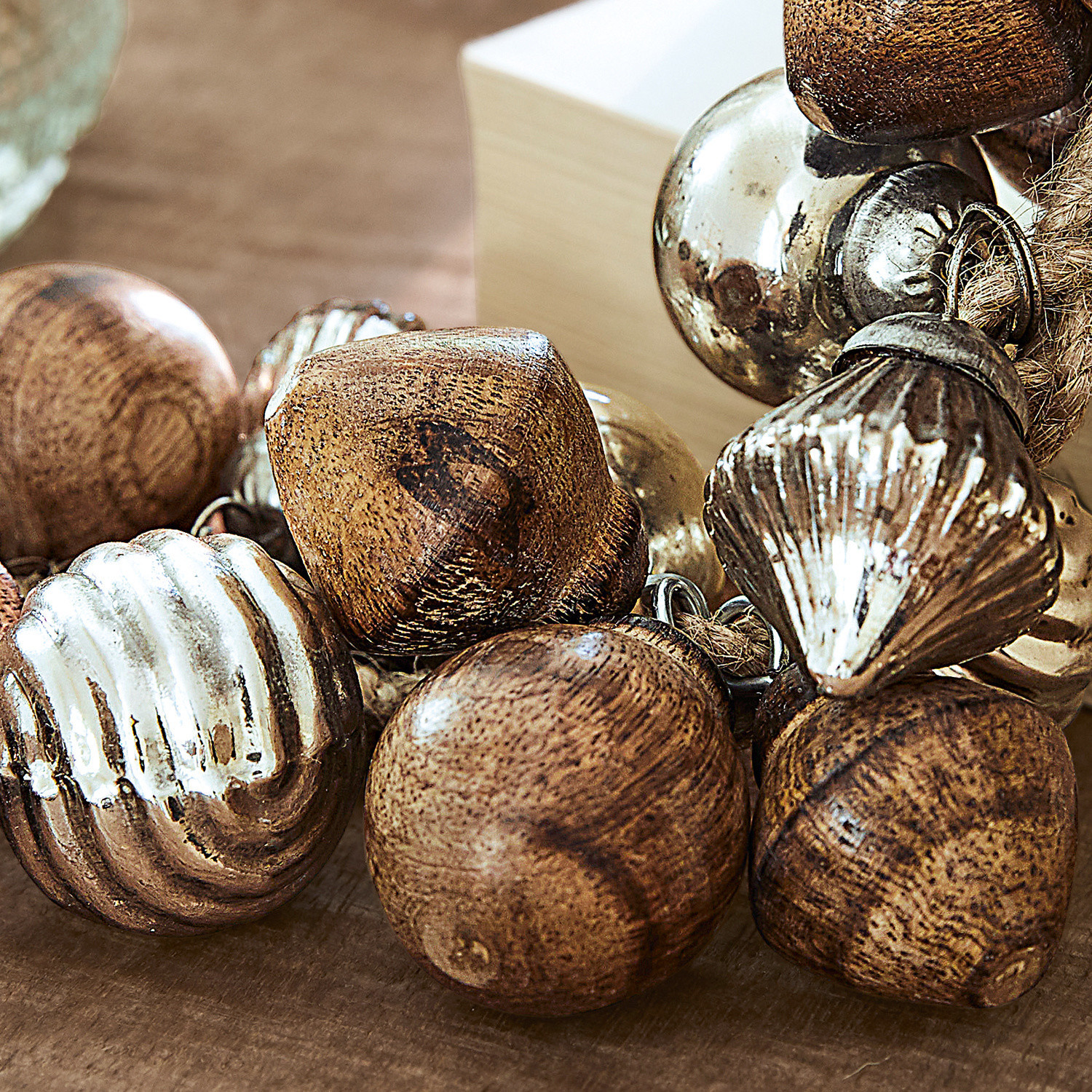 Dekorative Perlen aus Holz und Metall in Braun und Silber auf Kordel für Wohnaccessoires