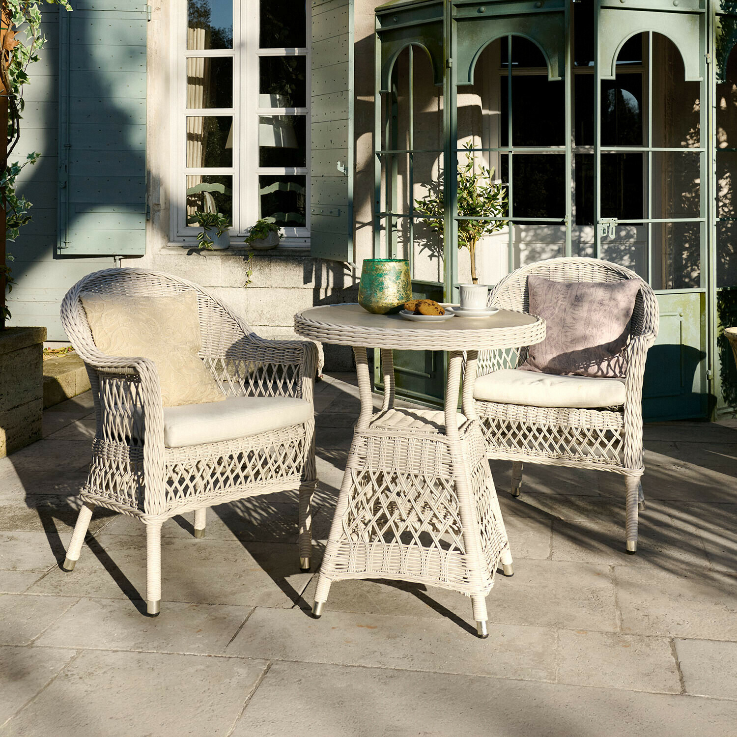 Sitzgruppe Solavine Weißes Rattan-Gartenmöbel-Set mit Kissen, runder Tisch und zwei Sesseln auf Terrasse
