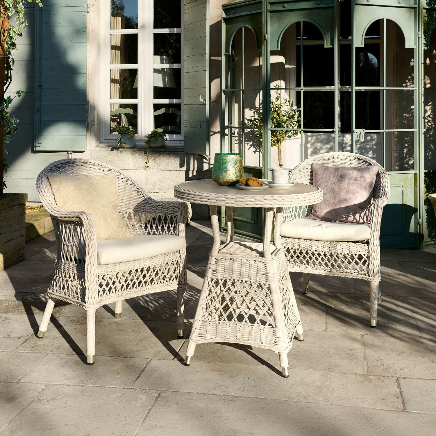 Sitzgruppe Solavine Weißes Rattan-Gartenmöbel-Set mit Kissen, runder Tisch und zwei Sesseln auf Terrasse