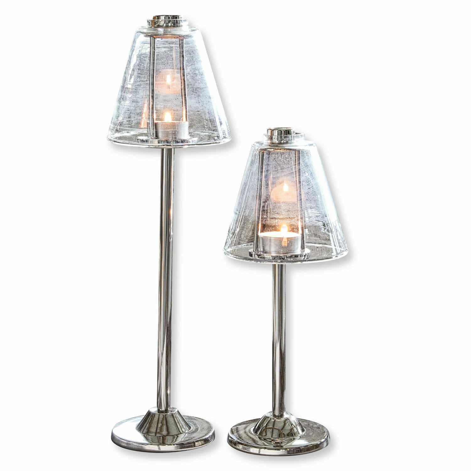 Set aus zwei Kerzenhaltern aus Edelstahl mit transparenten Glasschirmen und brennenden Kerzen