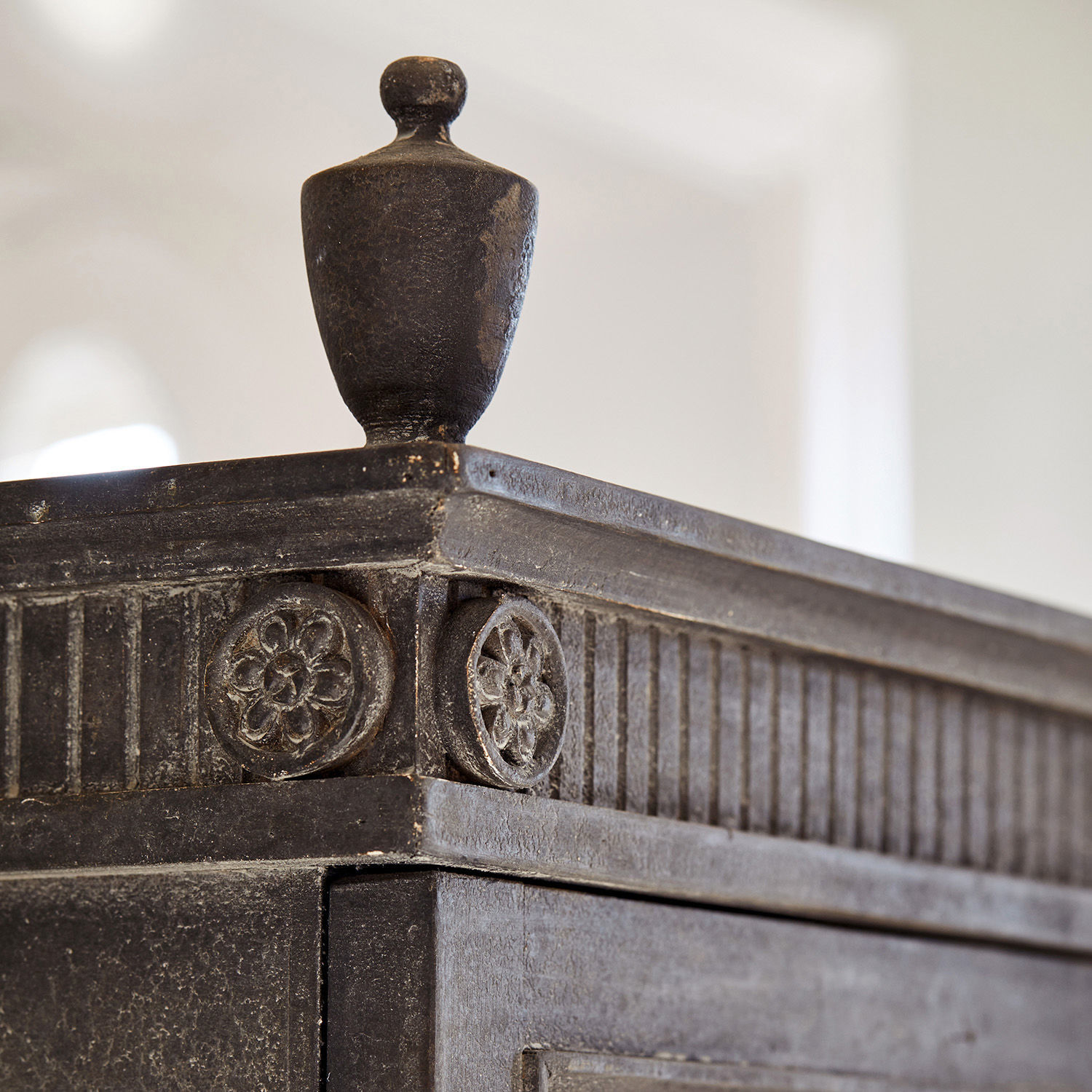 Schwarzes dekoratives Möbelteil aus Holz mit geschnitzten Blumenmotiven und Knauf
