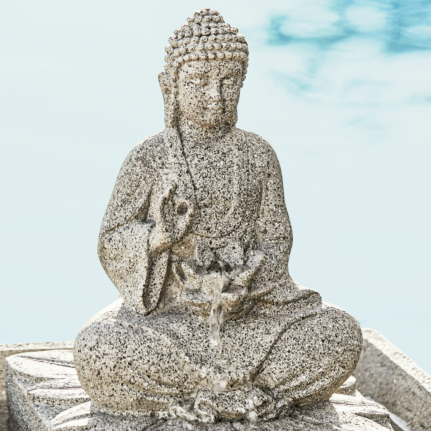 Buddha-Figur aus grauem Stein mit Wasser, das aus einer Lotusblüte fließt, Zen-Gartendekor