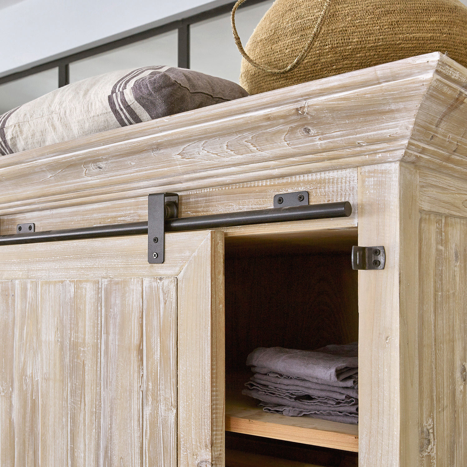 Heller Holzschrank mit Metallgriff und gefalteten Textilien im Regal, Aufbewahrungsmöbel