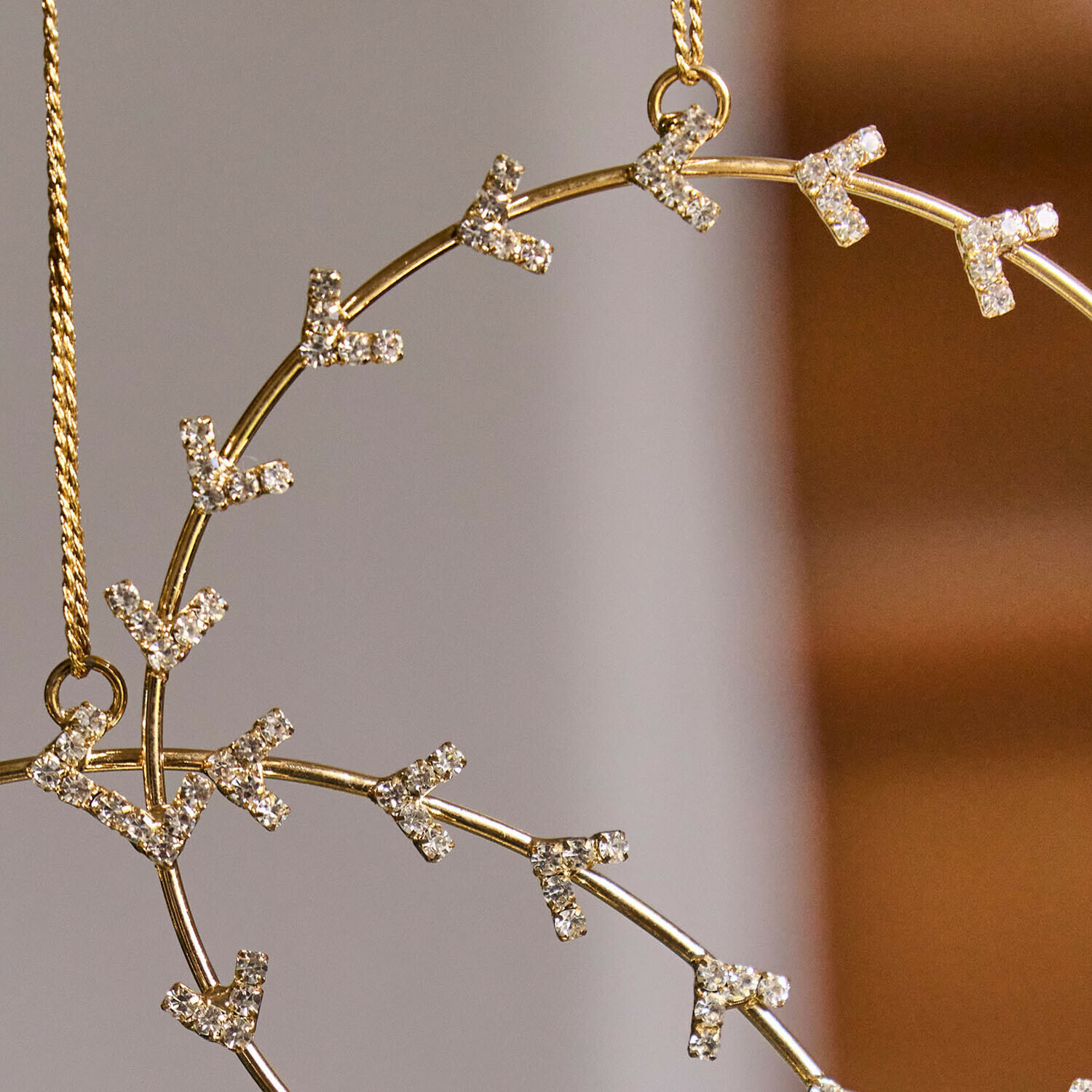 Goldener Anhänger mit funkelnden Kristallen an feiner Kette, eleganter Damenschmuck