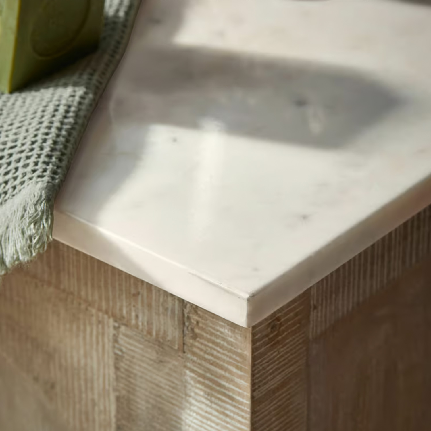 Weißer Marmorarbeitsplatte auf Holzunterbau mit grünem Stofftuch, moderner Möbelstil