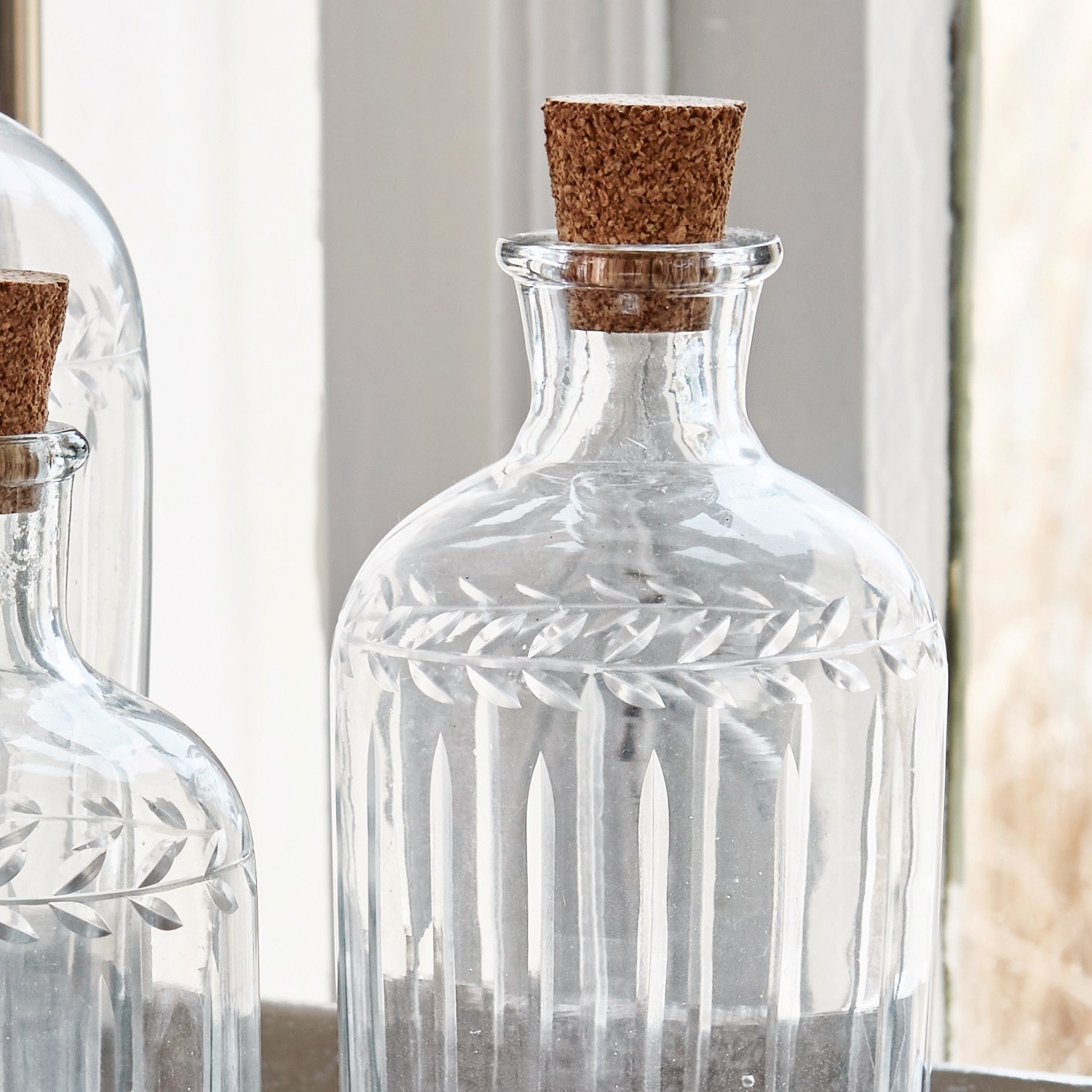 Transparante Glasflasche mit Korken und graviertem Blattmuster, dekorativer Behälter