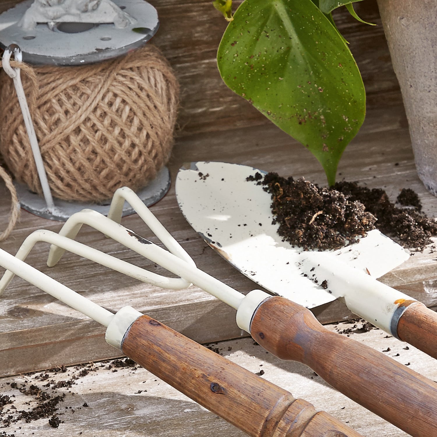 Gartengeräte-Set mit Holzgriffen und weißen Metallteilen zum Arbeiten im Boden