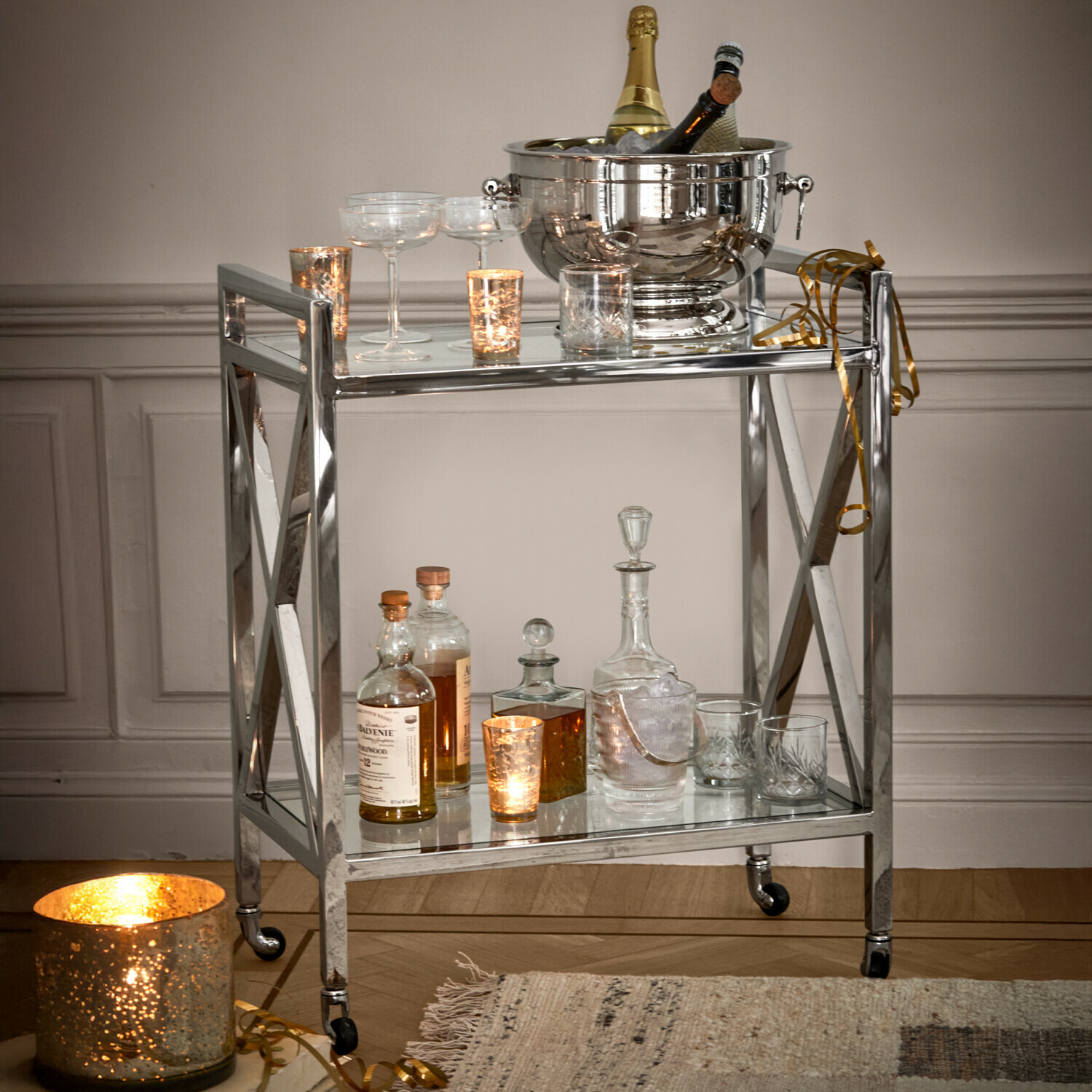 Eleganter Barwagen aus Edelstahl mit Flaschen und Gläsern, ideal zum Servieren von Getränken