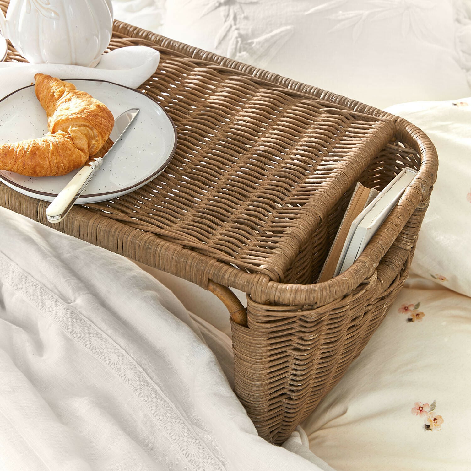 Brauner Rattantablett für das Bett mit Buchfach und Teller mit Croissant