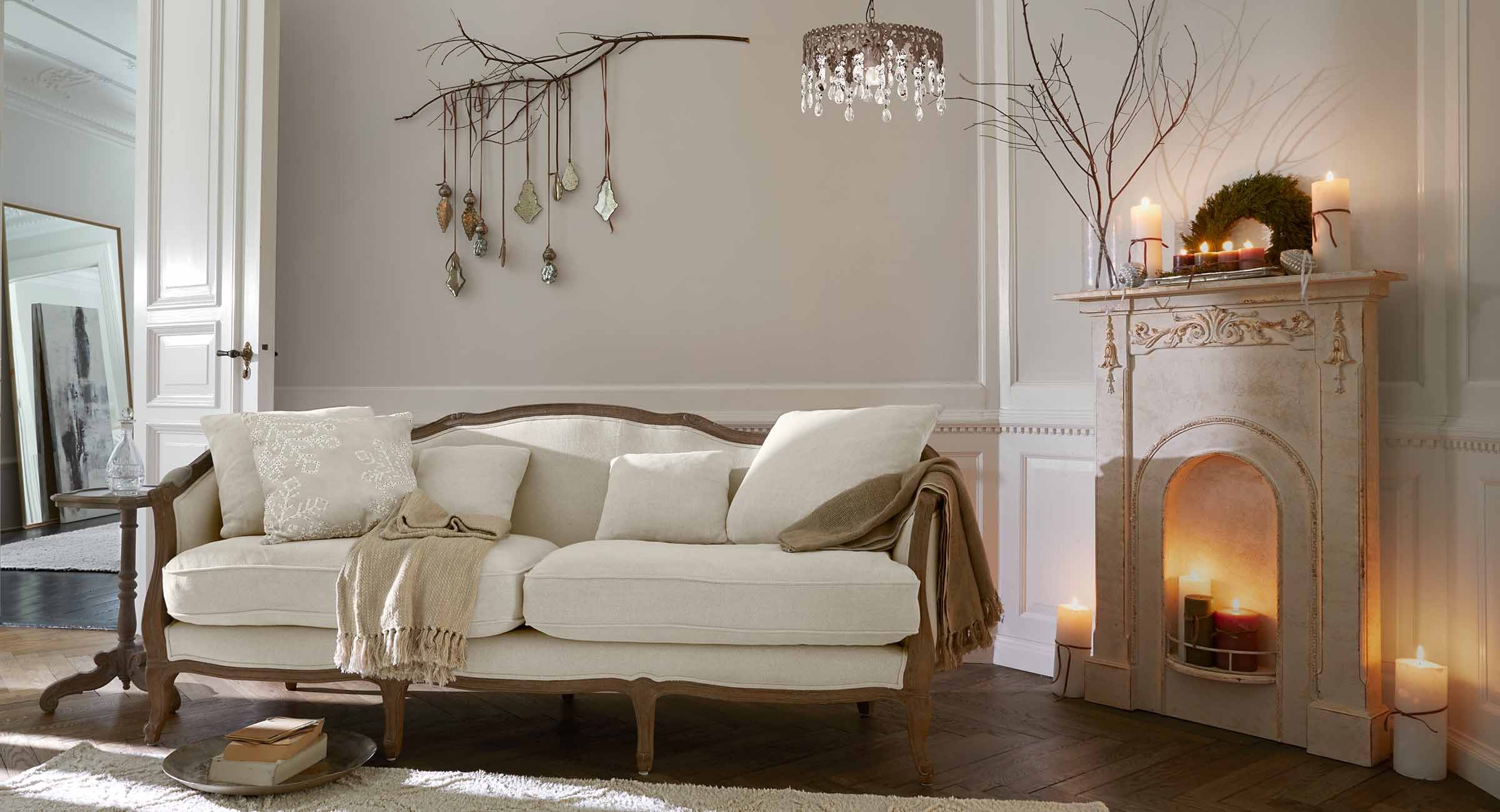 Beiges Sofa mit Holzrahmen in klassischem Wohnzimmer mit Kamin und Wanddekorationen