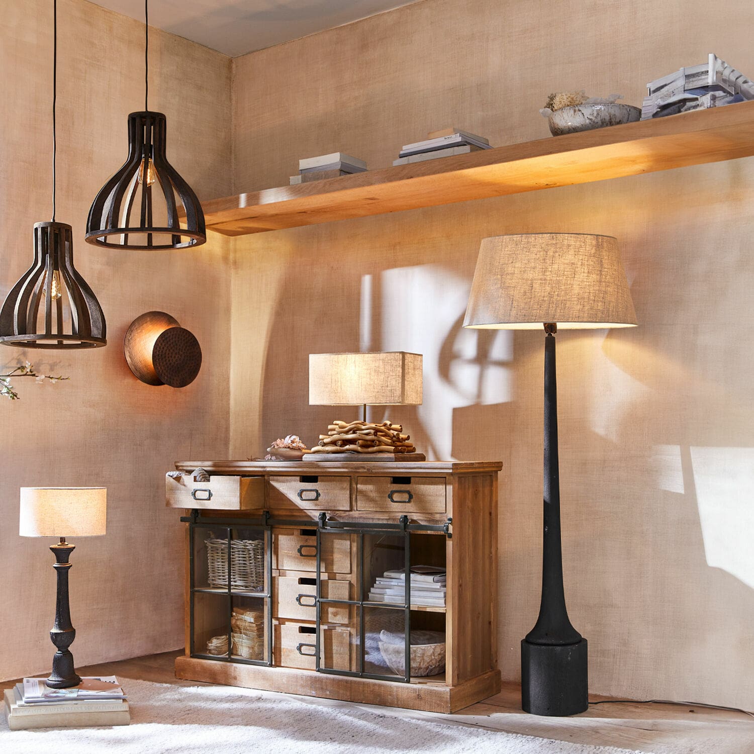 Holzkommode mit Schubladen und Glastüren, Tisch- und Stehlampen in natürlichen Farbtönen