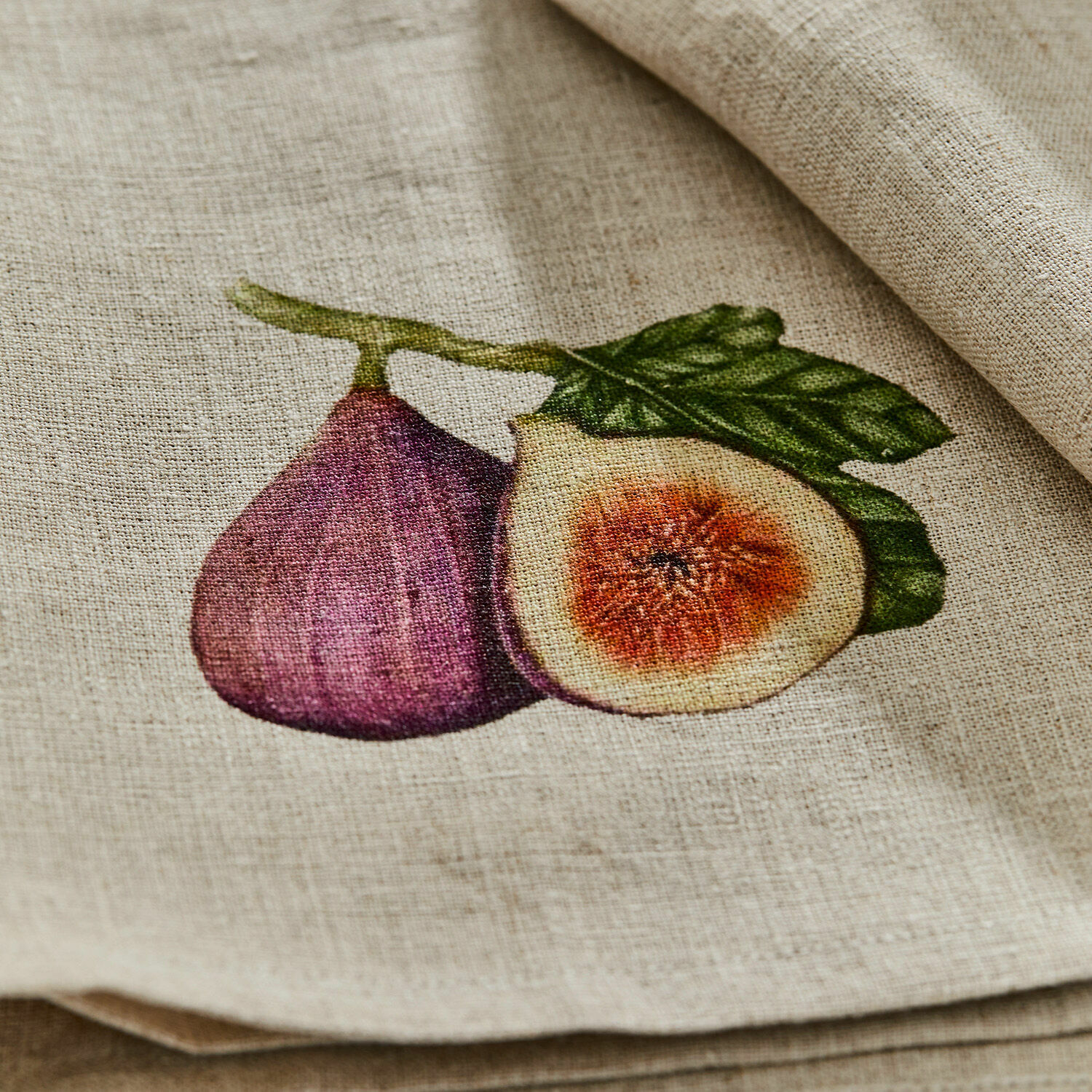 Leinenstoff in Naturfarbe mit bedruckter lila Feige und grünem Blatt für Dekoration