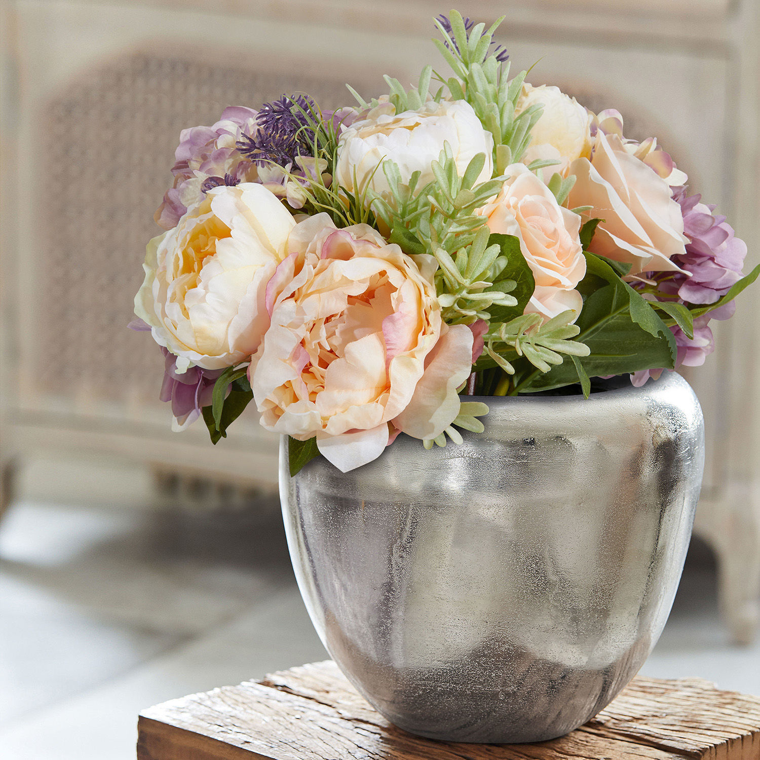 Silberne Keramikvase mit cremefarbenen und violetten Dekoblumen im Arrangement
