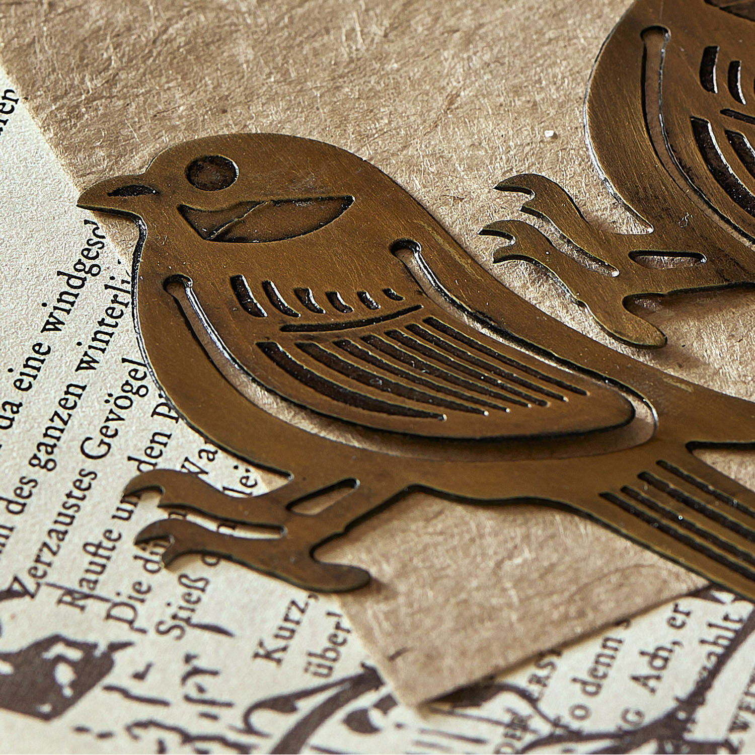 Metall-Dekoration in Vogel-Form aus Messing auf Papier mit Text, Vintage-Stil Accessoire