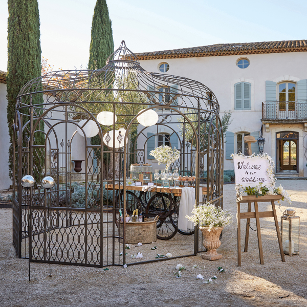 Metall-Gartenlaube im Vintage-Stil mit Dekorationen und Blumen für eine Außenveranstaltung