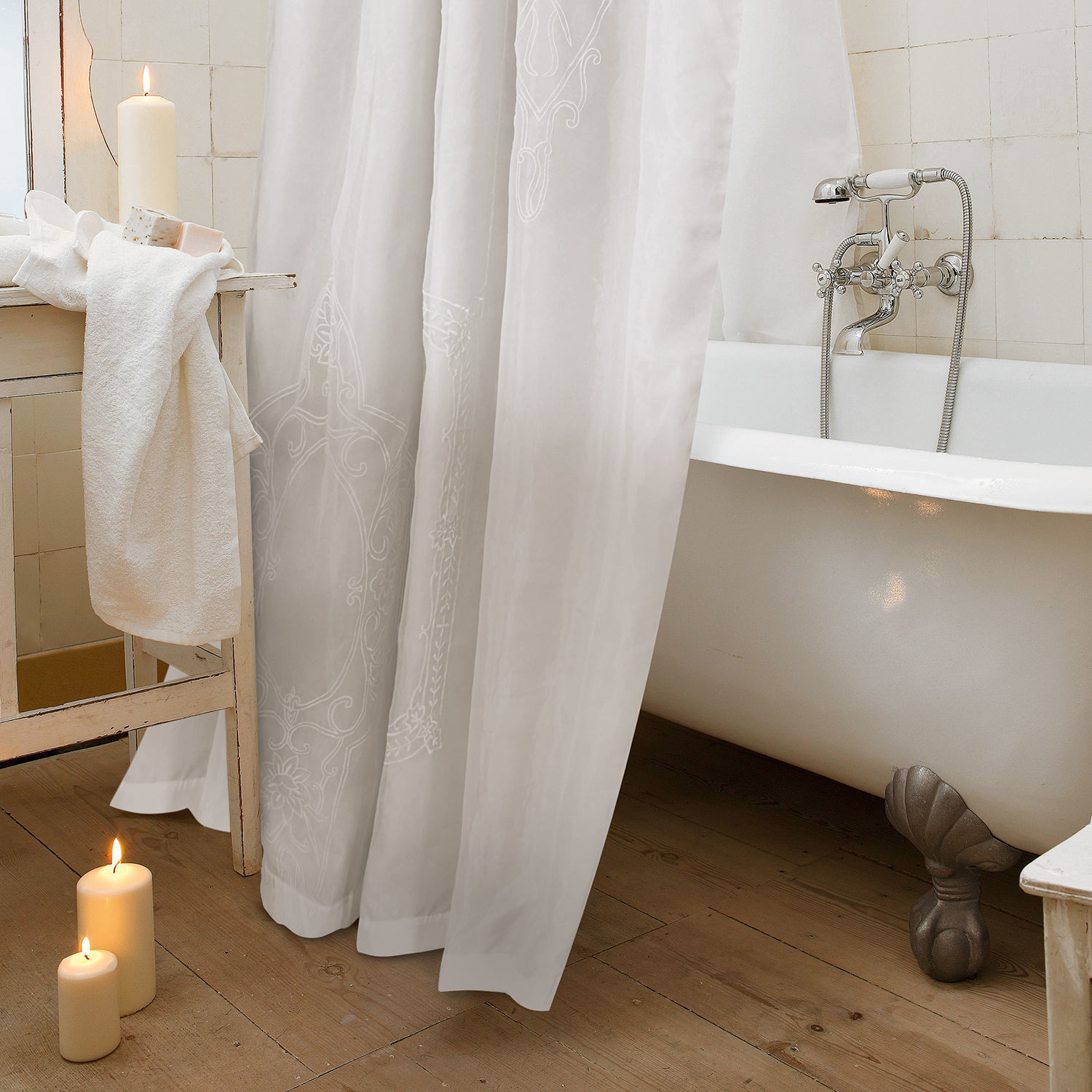 Weißer Duschvorhang mit feinem Muster, klassische Badewanne auf Löwenfüßen und Holzboden
