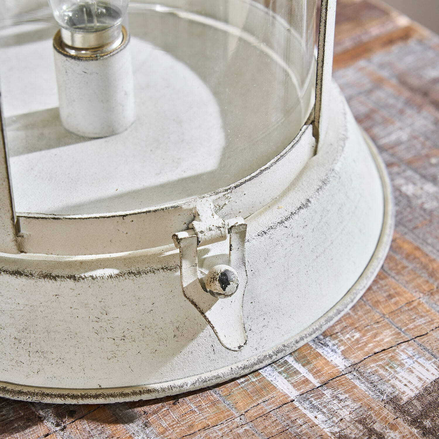 Weißer Metall-Laternenständer mit Glas und Verschluss auf Holztisch, dekoratives Wohnaccessoire