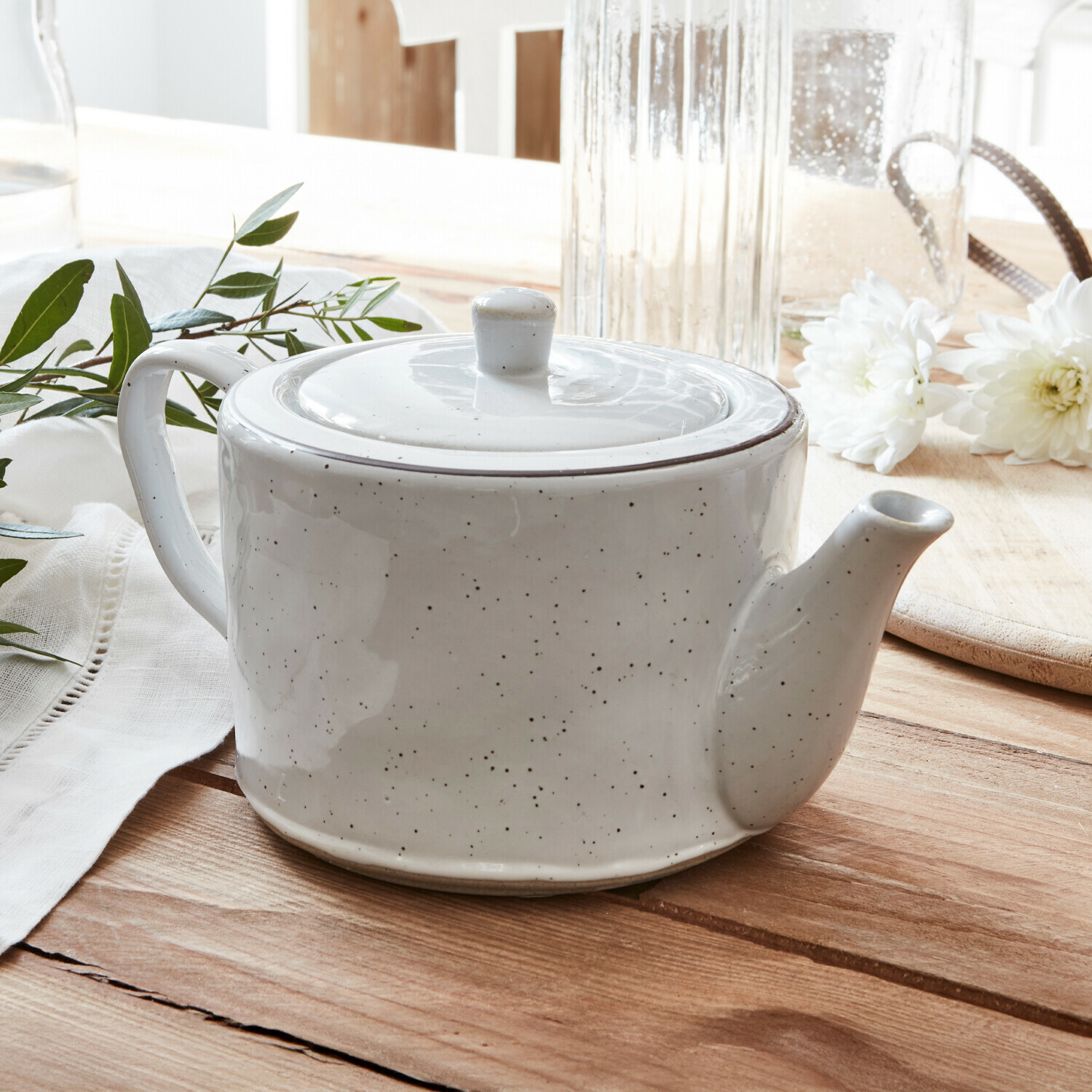 Teekanne Biarré Weiße Keramik-Teekanne mit Deckel auf Holztisch mit weißen Blumen und grünen Blättern dekoriert
