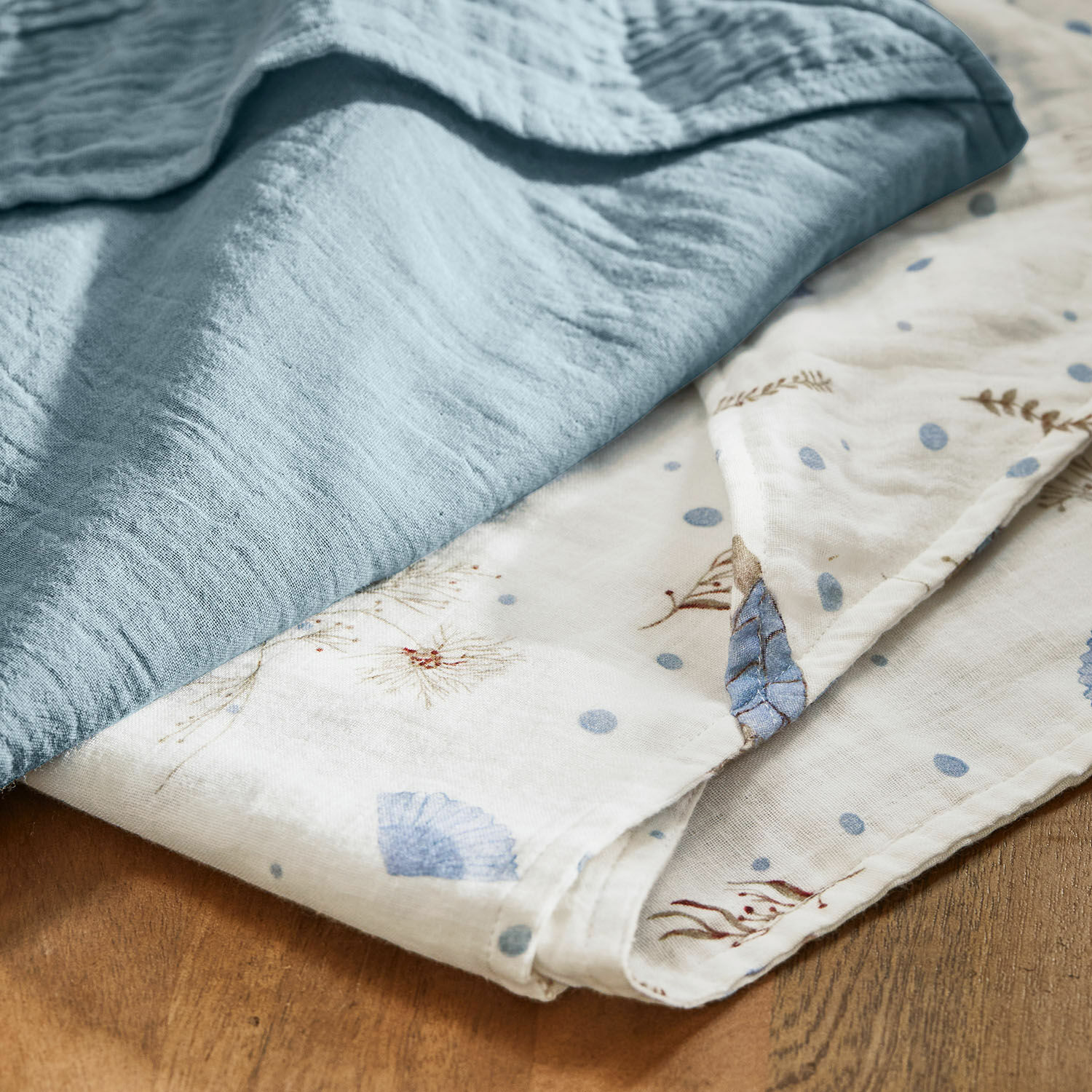 Weiche Baumwolldecke in Blau und Weiß mit zartem Pflanzenmuster, gemütlicher Heimtextilartikel
