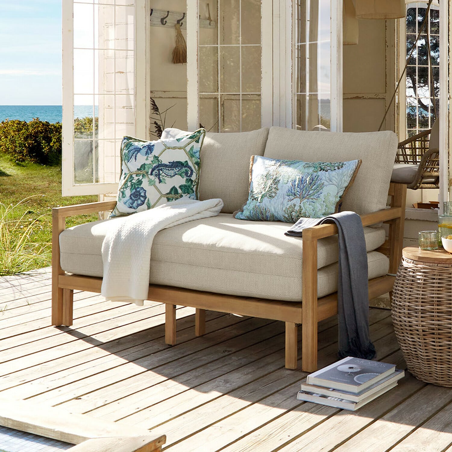 Ausziehsofa Tjorna Beiges Sofa mit Holzrahmen auf Terrasse mit Blick auf Garten und Meer, dekoratives Kissen