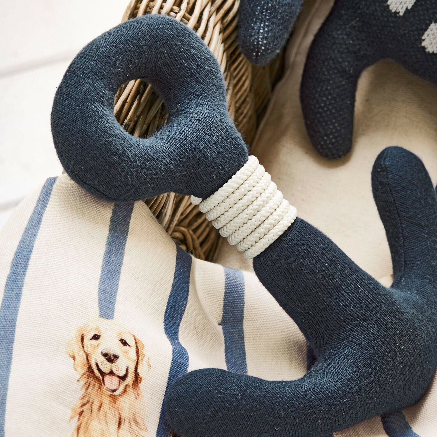 Marineblaue gestrickte Hundespielzeug mit weißem Seil auf Kissen mit Hundemotiv