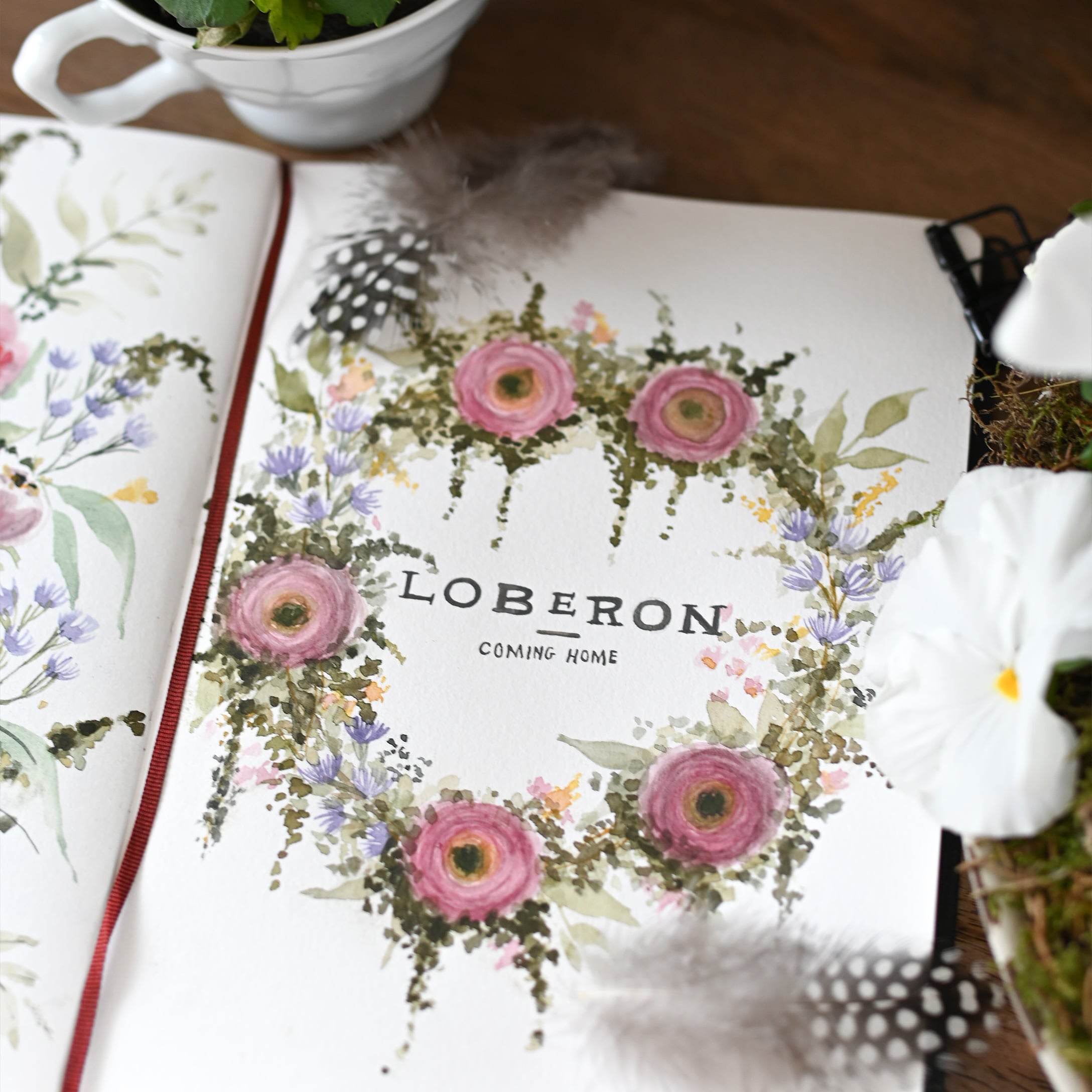 Aquarellierter Blumenkranz mit rosa und violetten Blüten, Federn und weißen Blumen auf Papier