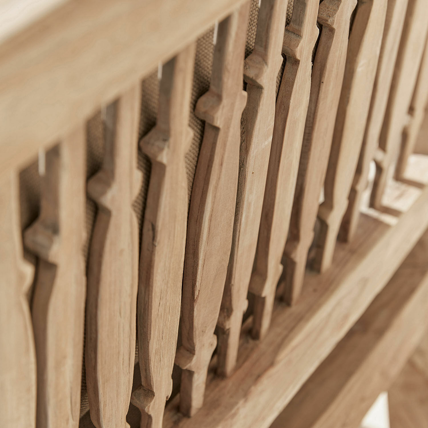 Detail eines Möbelstücks aus Naturholz mit dekorativen vertikalen Holzstäben