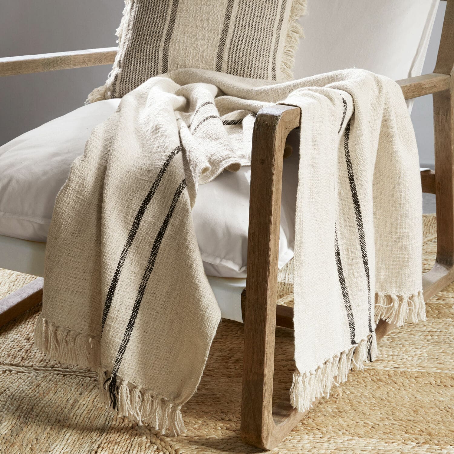 Plaid Toos Beige Baumwollplaid mit schwarzen Streifen und Fransen auf Holzstuhl im Wohnzimmer