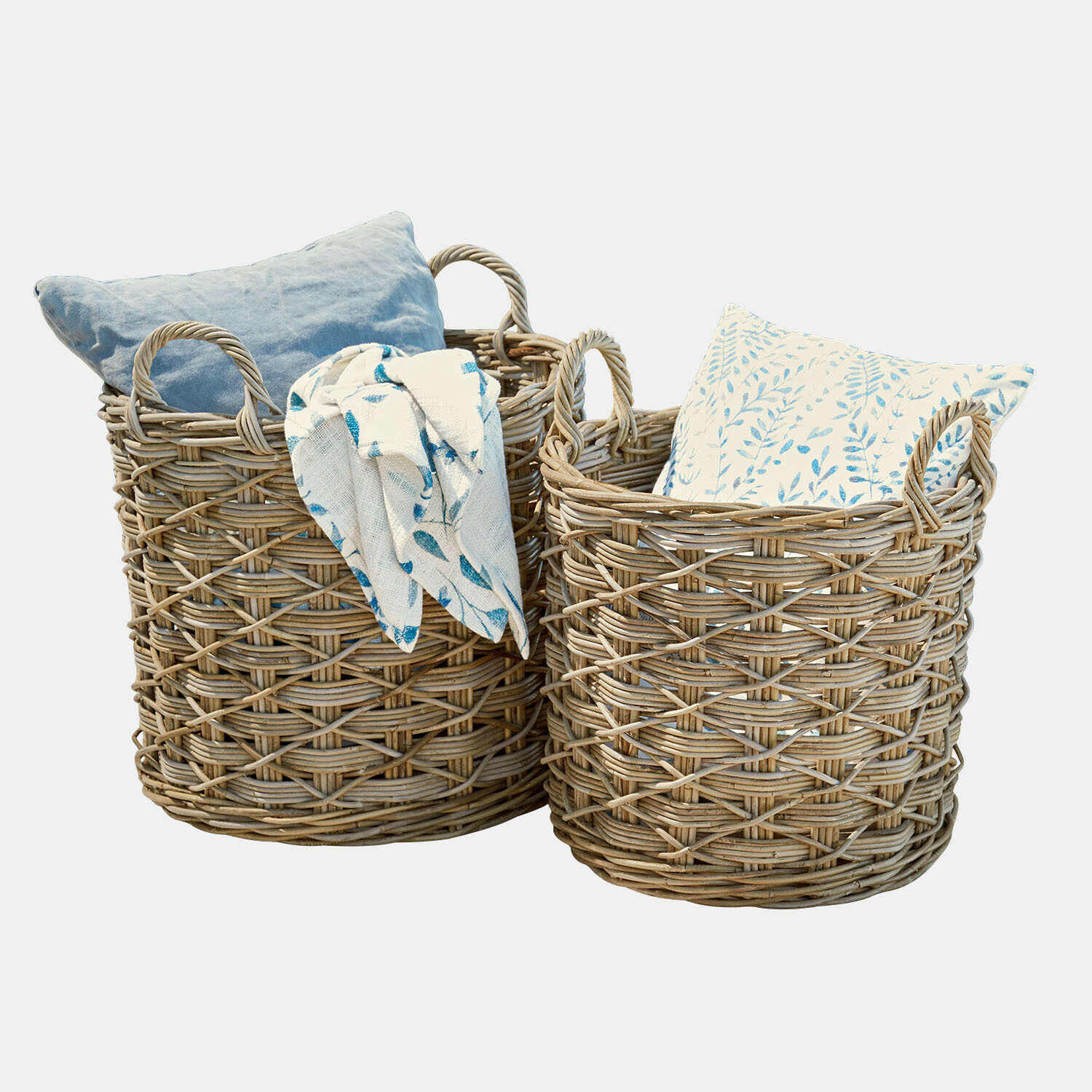 Zwei naturfarbene Weidenkörbe mit Kissen und blau gemusterter Decke zur Aufbewahrung