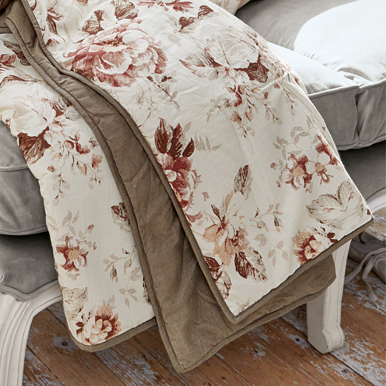 Baumwoll-Decke mit floralem Muster in Braun- und Beigetönen auf grauem Sofa, Wohnaccessoire