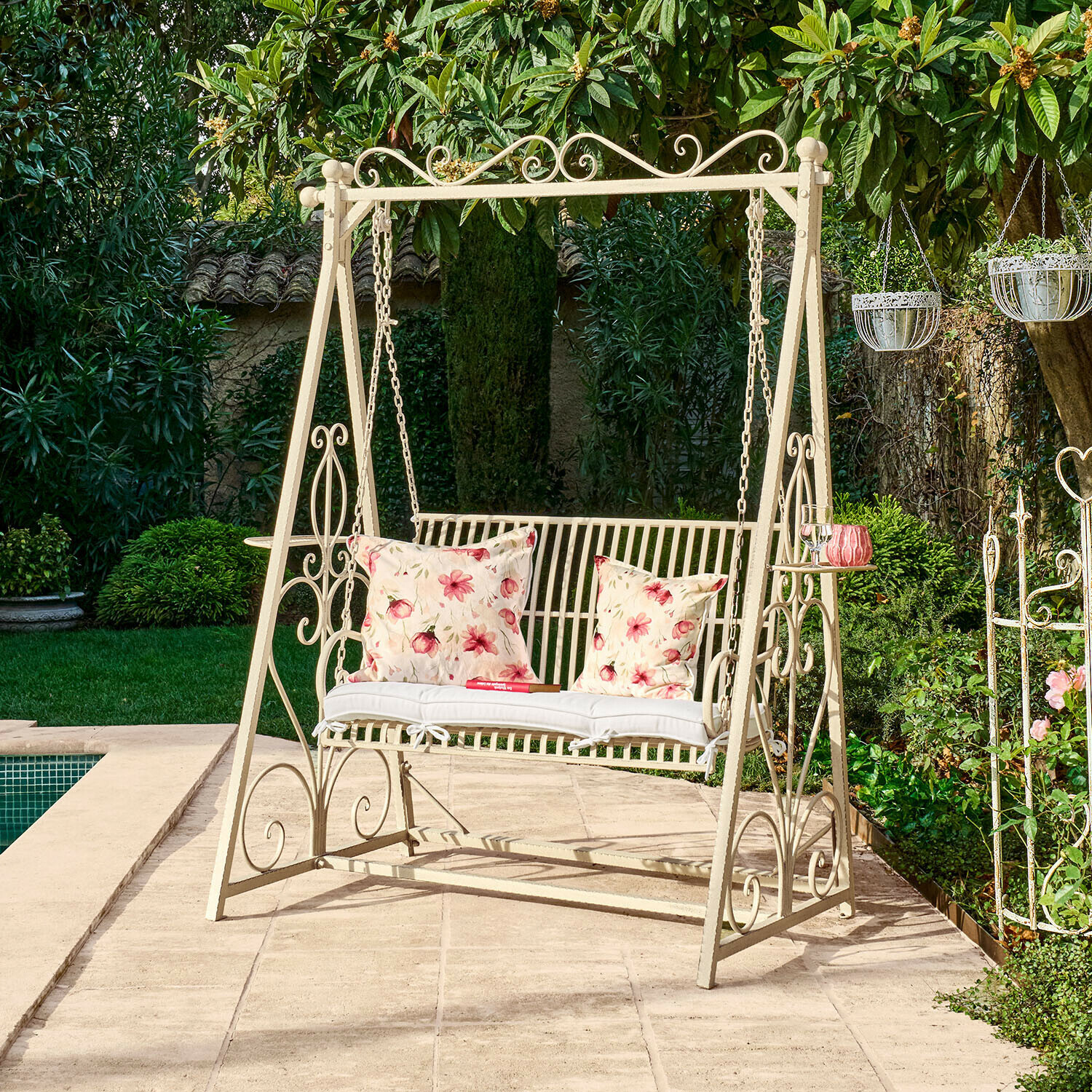 Hollywoodschaukel Iveralia Metall-Gartenschaukel in Creme mit floralen Kissen auf Terrasse neben Pool