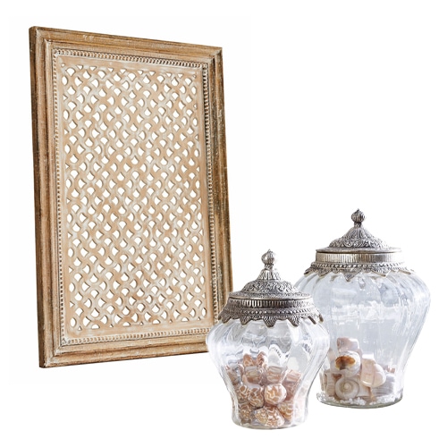 Holzrahmen mit filigranem Muster und zwei dekorative Glasgefäße mit Metalldeckeln im Vintage-Stil