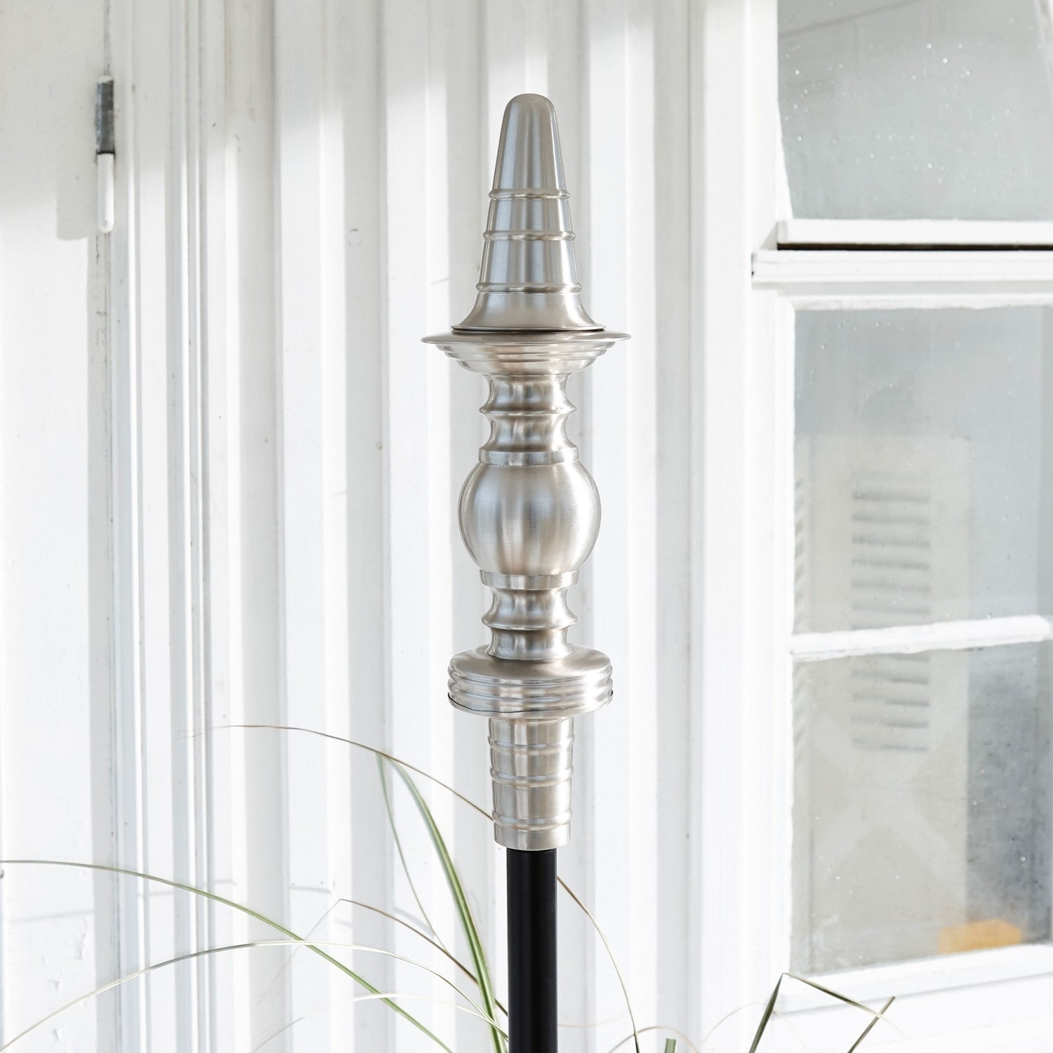 Silberne Metallspitze auf schwarzem Stab als dekoratives Element für Haus und Garten