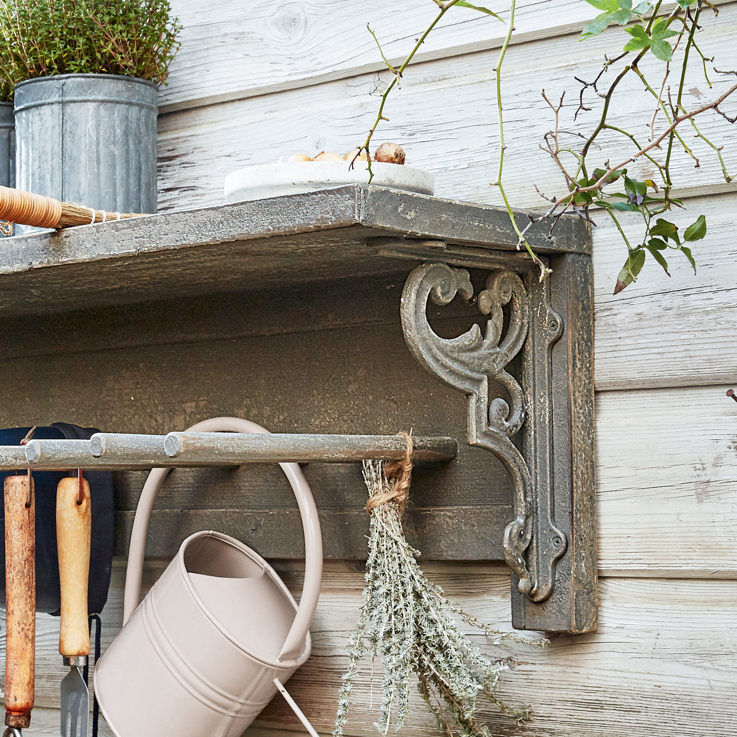 Metall-Wandregal in Grau mit dekorativem Halter und Gartenwerkzeugen zum Pflanzenpflegen